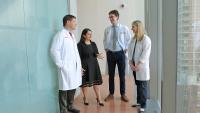 Four physicians talking in a hallway.